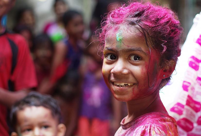 A young girl covered in pink paint celebrates in Mumbai, India.