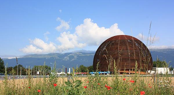 Outside view of Cern in Switzerland amid blue sky and fields of flowers