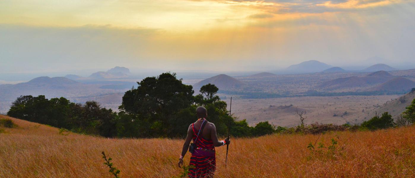A man walking through a field in Kenya