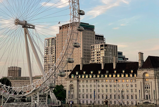 London Eye in the foreground with London skyline behind it at dusk