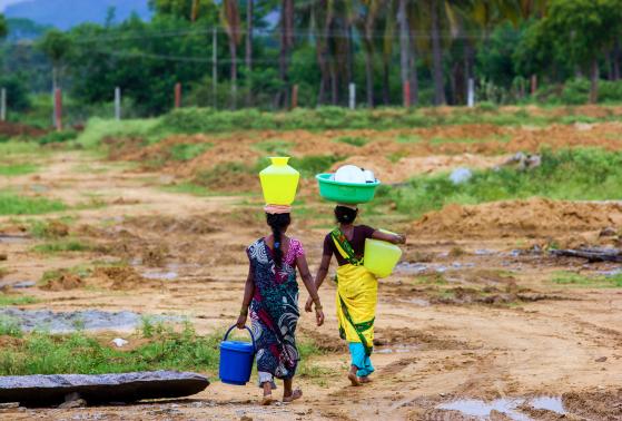 Women collect water during monsoon season in India