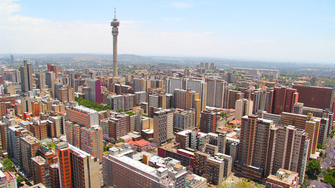 Aerial view of Johannesburg cityscape with high-rise buildings and a telecom tower rising above the skyline
