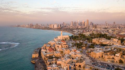 Aerial view of Tel Aviv coast and cityscape with historic buildings in the foreground and modern skyscrapers in the background