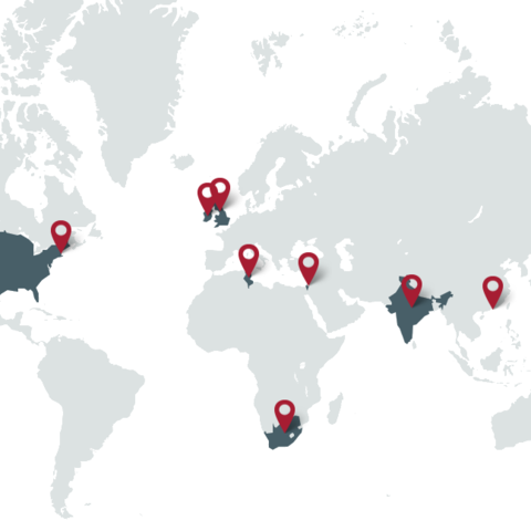 map of the world with crimson pins indicating where Harvard Global has entities
