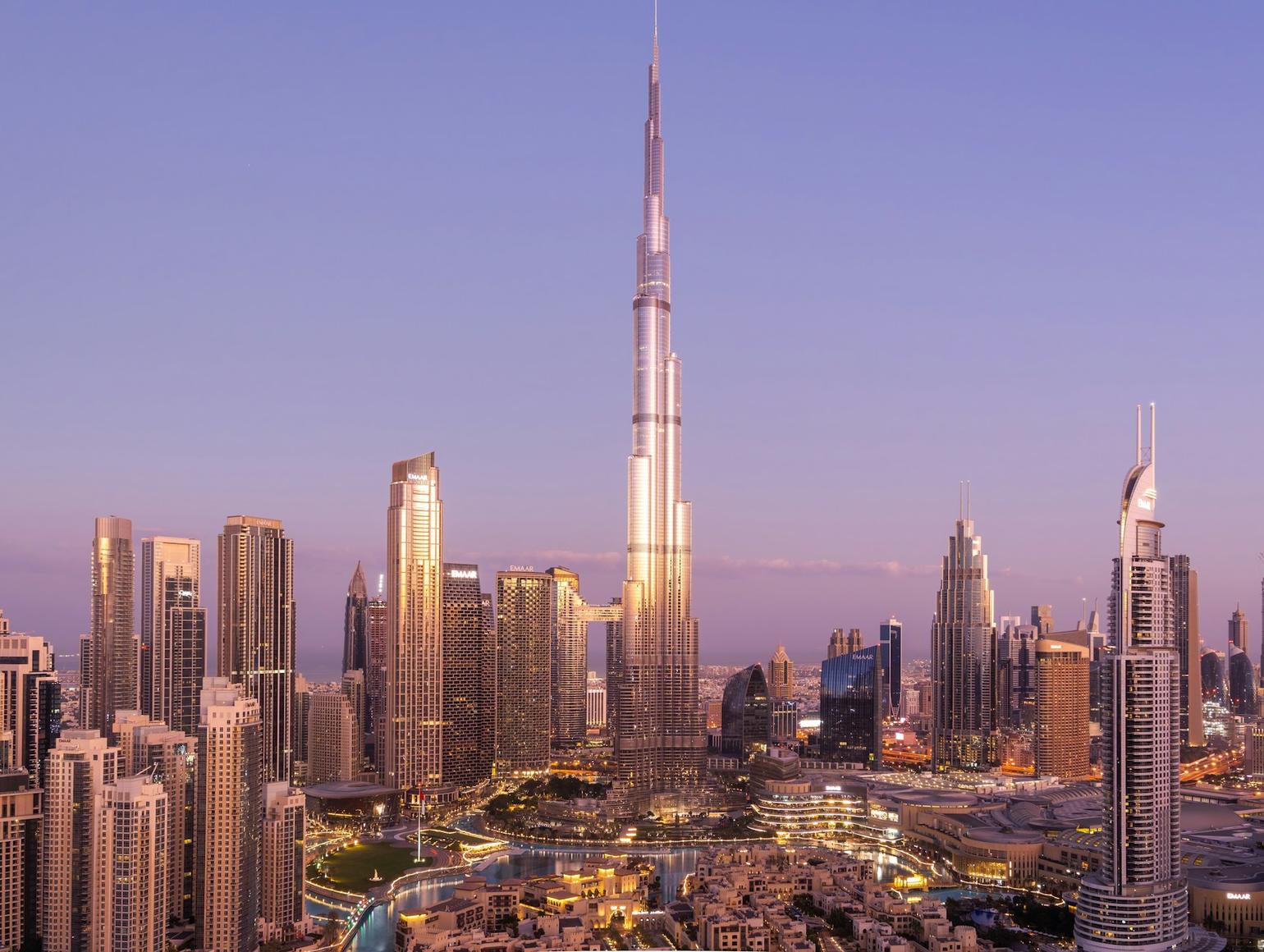 Dubai skyline at sunrise featuring Burj Khalifa, the tallest building in the center, surrounded by modern skyscrapers
