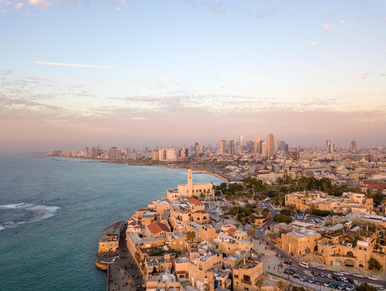 Aerial view of Tel Aviv coast and cityscape with historic buildings in the foreground and modern skyscrapers in the background
